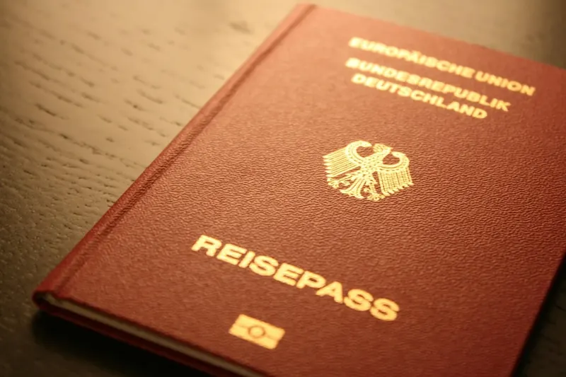 Symbolbild: Deutscher Reisepass mit Bundesadler auf einem Holztisch